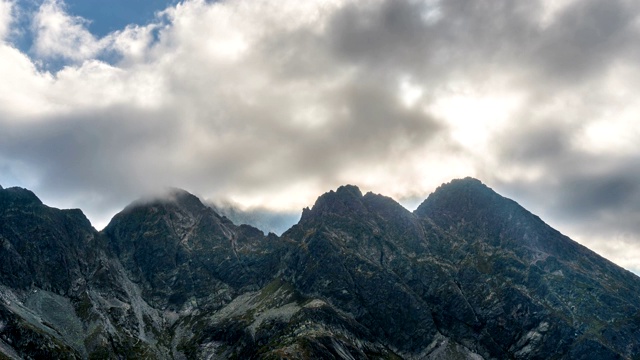 戏剧性的云和阳光在阿尔卑斯山顶。在阳光明媚的夏日里渐渐变黑时光流逝视频素材