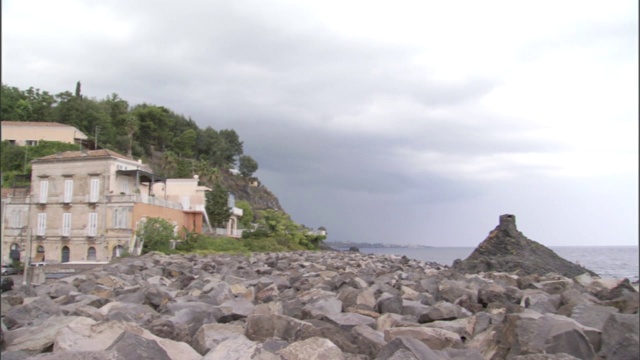 在意大利西西里岛的岩石海岸外，暴风雨的乌云笼罩着地中海。视频素材