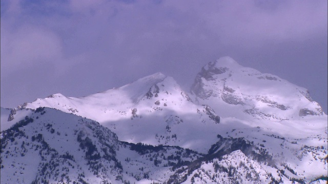 云朵在大提顿山脉白雪覆盖的山峰附近徘徊。视频素材