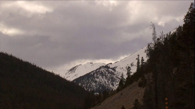 在科罗拉多州，乌云笼罩着多雪、树木繁茂的山脉。视频素材