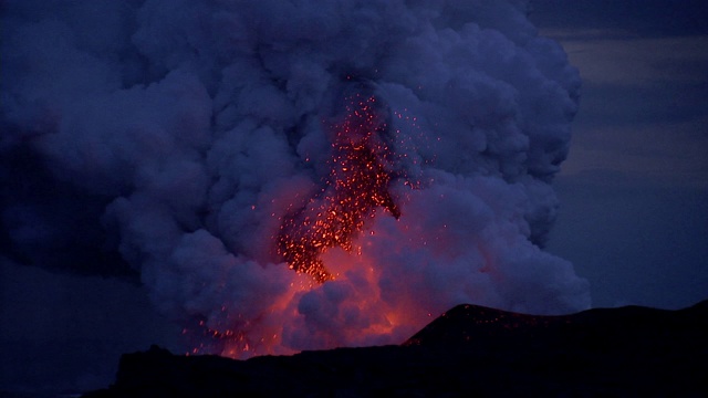 晚上，夏威夷莫纳克亚火山爆发出炽热的岩浆和巨大的蒸汽云团。视频素材