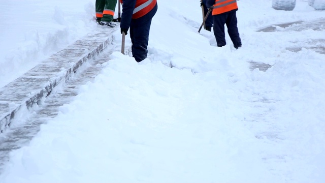 工人们用铁锹清除城镇广场楼梯上的积雪。视频素材