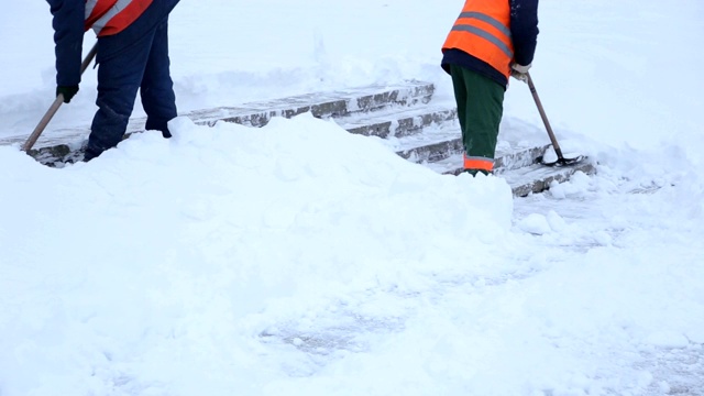 工人们用铁锹清除城镇广场楼梯上的积雪。视频素材