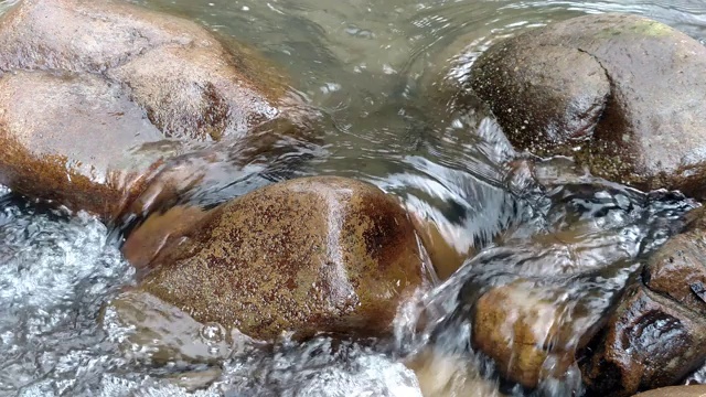 水流过石头被河水冲刷的巨石天然岩石上惊人的瀑布运动流畅视频下载