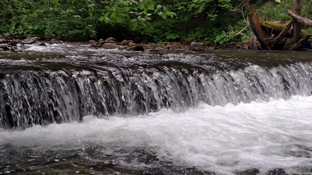 宽阔的瀑布在一个山河在黑暗的夏天的日子泡沫水瀑布瀑布视频素材