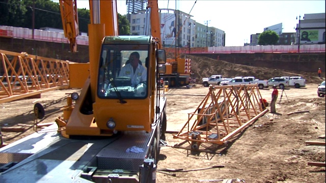 建筑工人在建筑工地驾驶起重机。视频素材