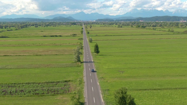 无人机:跟在一辆自动驾驶汽车后面，沿着笔直的乡村道路行驶。视频素材