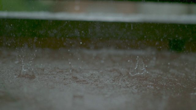 清新的春雨冲刷着门廊的棕色瓷砖地面。视频素材