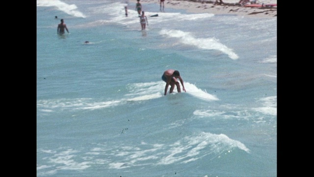 在迈阿密，冲浪者乘风破浪进入海岸;1968视频素材