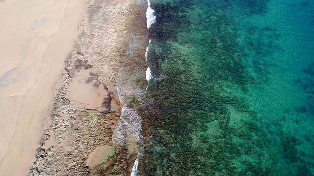 无人机鸟瞰海浪在沙滩上破碎视频素材