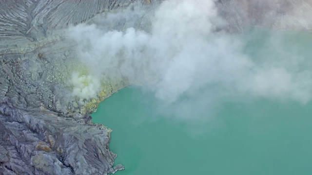 鸟瞰图的岩石悬崖在卡瓦伊真火山与绿松石硫水湖在日出。全景在东爪哇，印度尼西亚。自然景观背景。视频素材