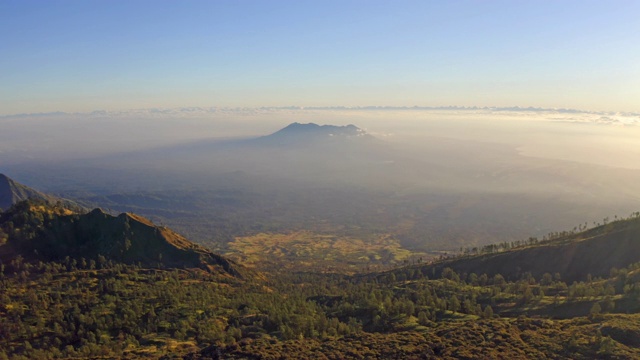 鸟瞰图的岩石悬崖在卡瓦伊真火山与森林和雾云在日出。全景在东爪哇，印度尼西亚。自然景观背景。视频素材