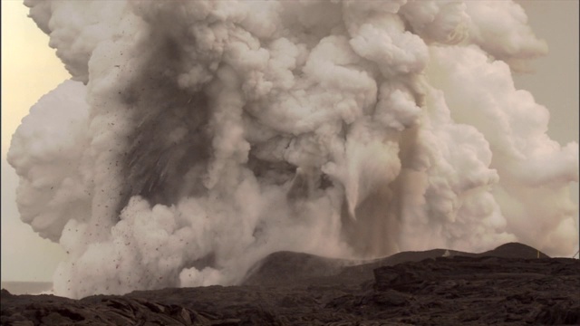 熔岩喷出时，厚厚的灰白色烟雾从火山口翻腾而出。视频素材