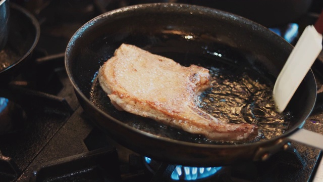 一位专家在平底锅里煮猪肉排视频素材