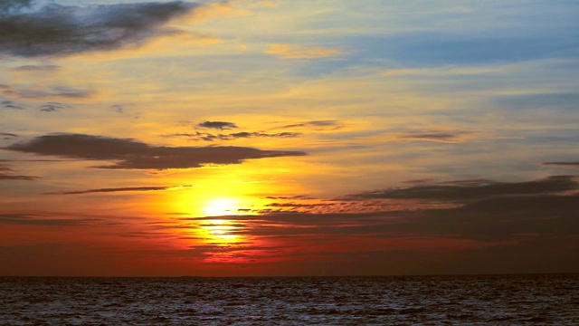 夕阳橙色的天空和暗红色的云移动，海浪在海上视频素材