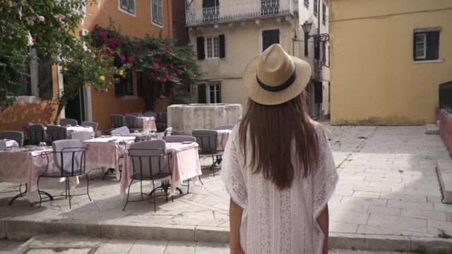 旅行者年轻美丽的女人徒步探索古老的欧洲小镇Kerkyra，科孚岛，希腊。视频素材