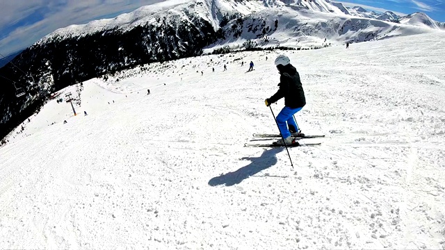 跟踪专业运动滑雪者在高山滑雪度假村的山上滑雪道，电影慢动作POV视频素材