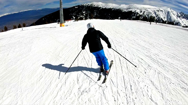 跟踪专业运动滑雪者在高山滑雪度假村的山上滑雪道，电影慢动作POV视频素材