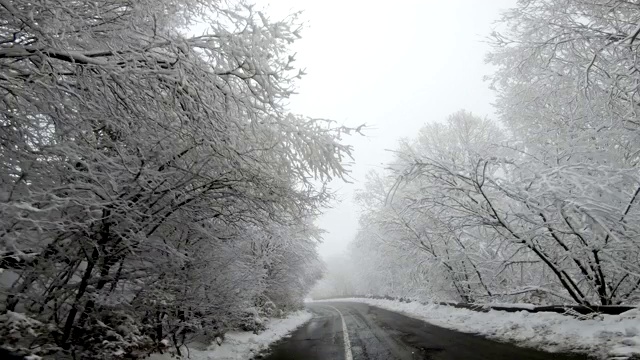 快速行驶的汽车在下雪的冬季道路上，能见度低，有雾视频素材