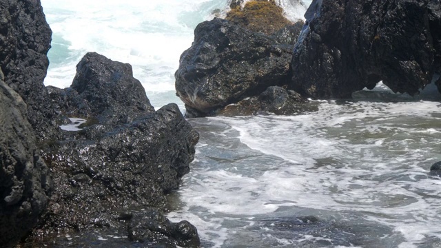 海浪撞击熔岩岩潮池的特写，每帧60秒视频素材