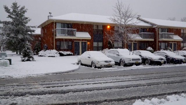 冬天下大雪时，城市街道上的汽车被积雪覆盖视频素材