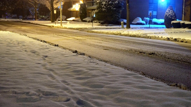 冬夜白雪覆盖的乡村小区道路上，冬夜自然车灯步道视频素材