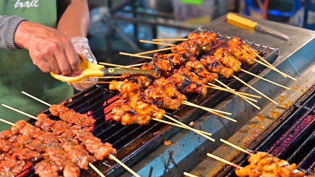 近距离的手翻肉在烧烤的街头食品，泰国视频素材