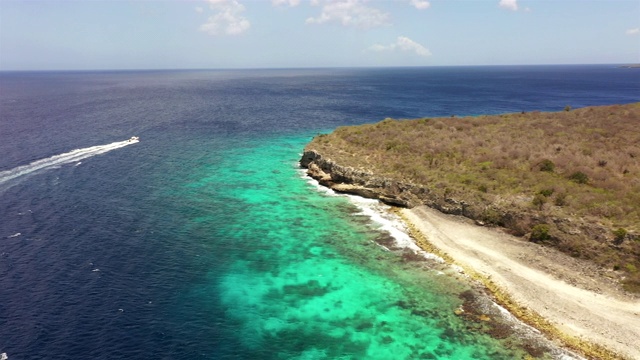 鸟瞰图Curaçao海岸在加勒比海与船在碧绿的水，悬崖，海滩和美丽的珊瑚礁附近拉古视频素材