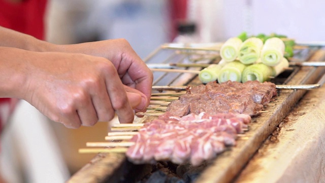 在街边的一家餐馆里，厨师们正在炉子上烧烤。视频素材