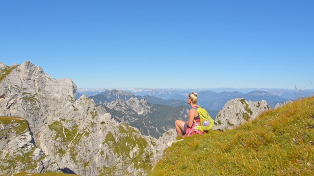 女徒步旅行者欣赏着山景视频素材