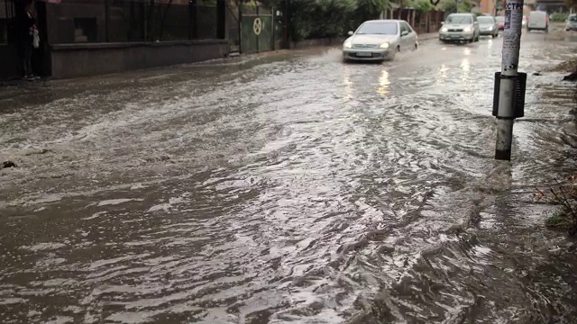 汽车穿过被洪水淹没的城市街道视频素材