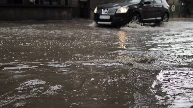 汽车穿过被洪水淹没的城市街道视频素材