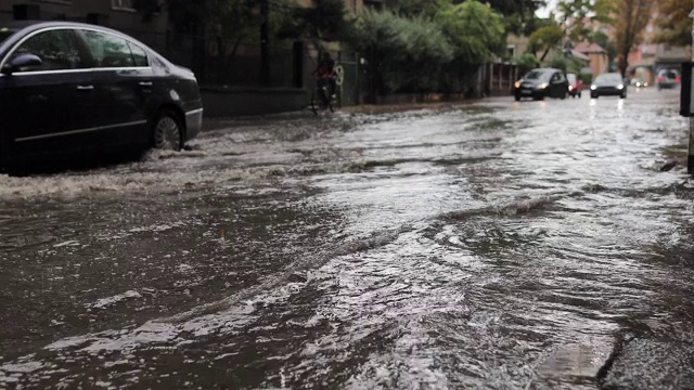 汽车在雨中行驶在被淹没的道路上视频素材