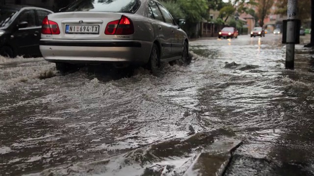 汽车在雨中行驶在被淹没的道路上视频素材