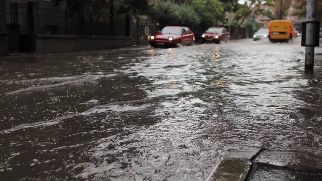 汽车穿过被洪水淹没的城市街道视频素材