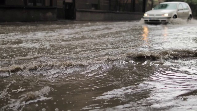 汽车穿过被洪水淹没的城市街道视频素材