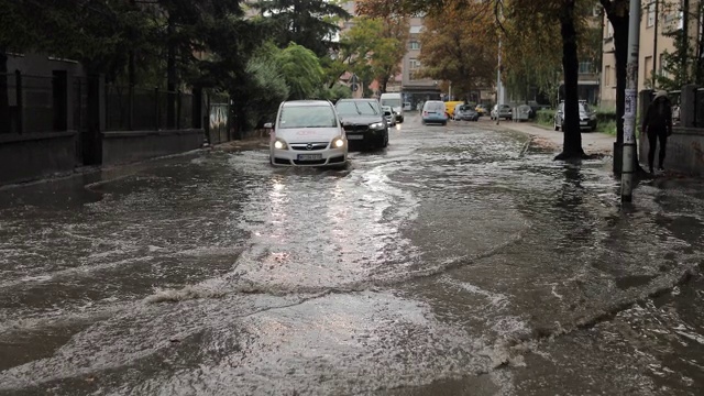 汽车穿过被洪水淹没的城市街道视频素材