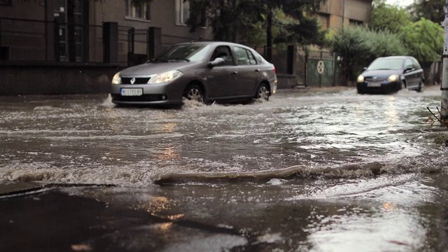 汽车穿过被洪水淹没的城市街道视频素材