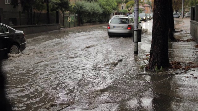 汽车穿过被洪水淹没的城市街道视频素材