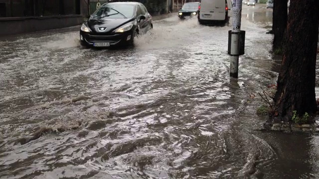 汽车在雨中行驶在被淹没的道路上视频素材