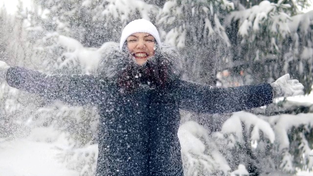 快乐的女人在冬天的森林里享受降雪。在新鲜空气中散步视频素材