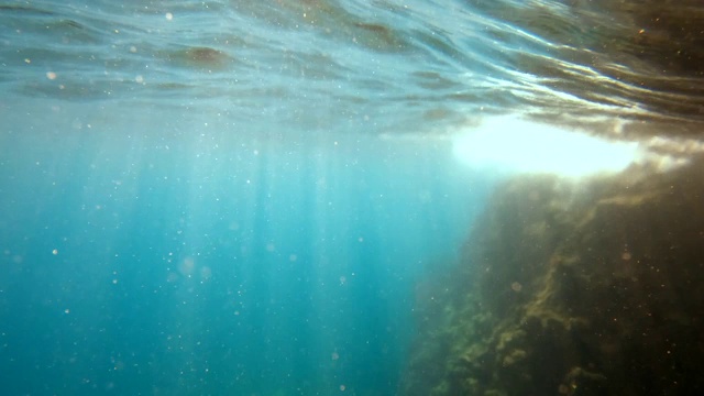 在水下的阳光下，海浪随着光线振荡和流动视频素材