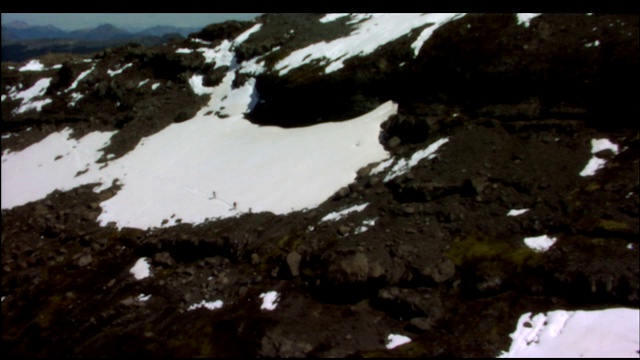 登山者在雪和岩石上艰难跋涉。视频素材