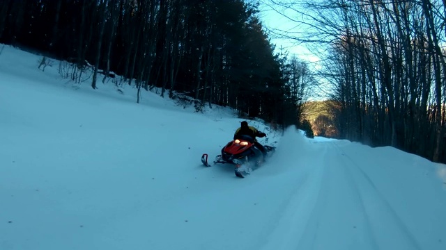 在冬天骑着雪地摩托沿着结冰的道路行驶视频素材