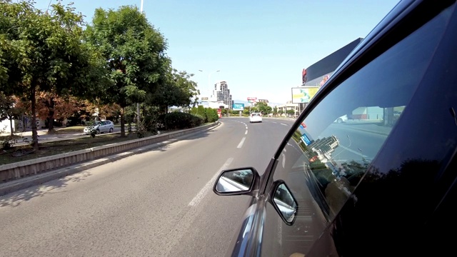 在城市中驾驶汽车——POV，从车的侧面拍摄的第一人称视角视频素材