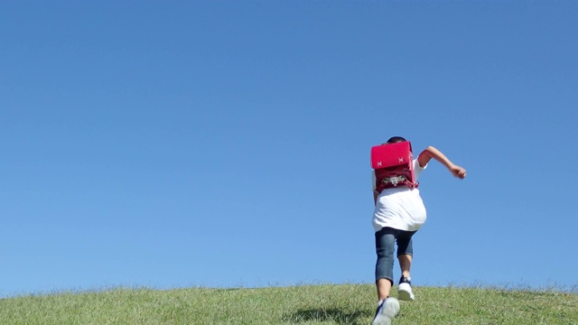 日本小学女孩在蓝天下奔跑的背影视频素材