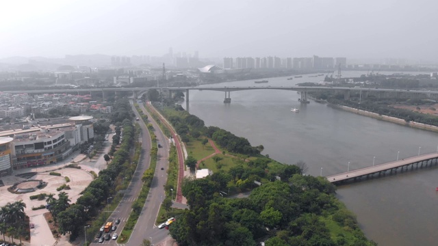 四轴飞行器沿着河边的道路驶向大桥。视频素材