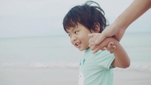 母子光着脚走在白色的沙滩上视频素材