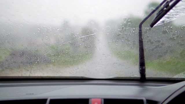 下雨时开车，挡风玻璃上的雨刷把雨擦去。视频素材