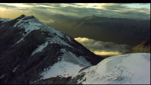 登山者横越积雪的山坡。视频素材